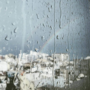 rainbow outside a raining window